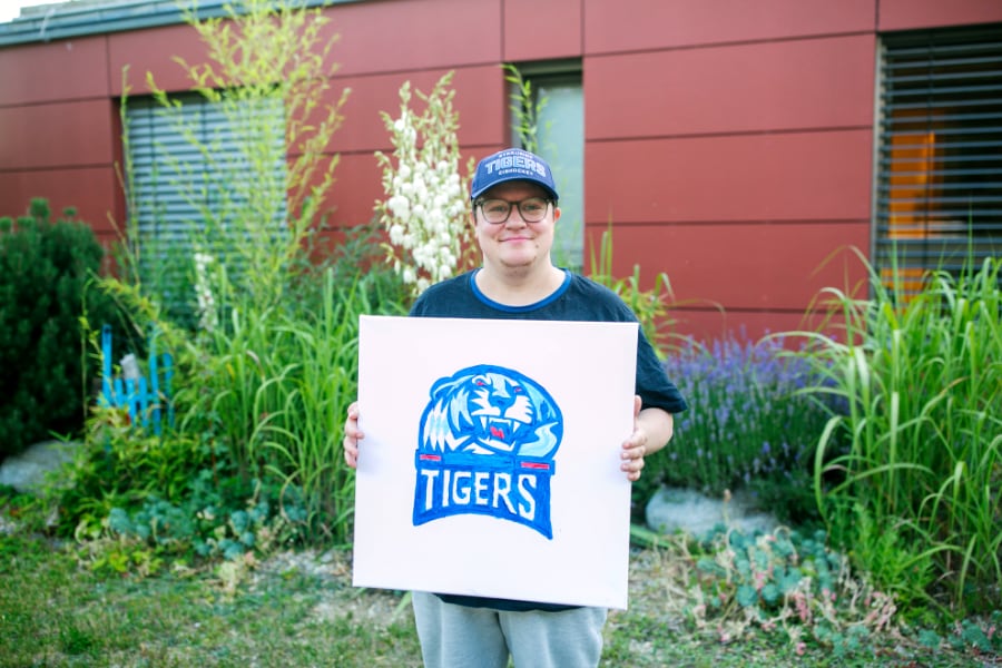 Person hält ein Logobild der Tigers