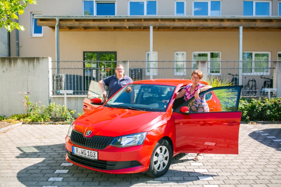 2 Personen am roten Auto