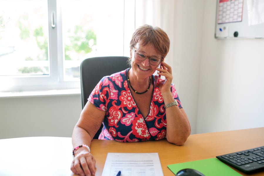 Frau telefoniert am Schreibtisch