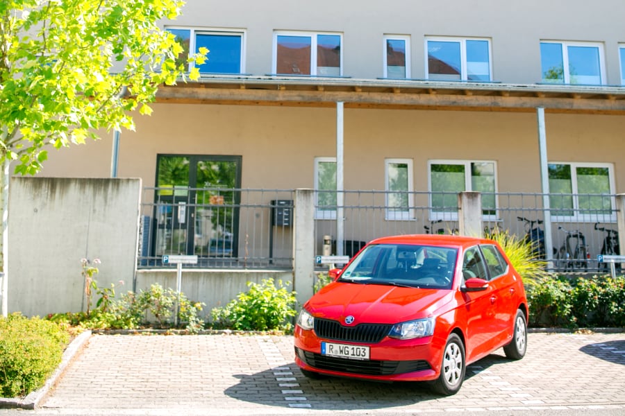 Rotes Auto aufm Parkplatz vom Haus